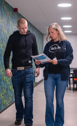 Opinto-ohjaaja ja opiskelija kävelevät käytävällä.