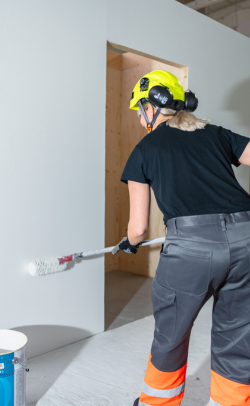 Opiskelija maalaa seinää pintakäsittelyalan perustutkinto -koulutuksessa.