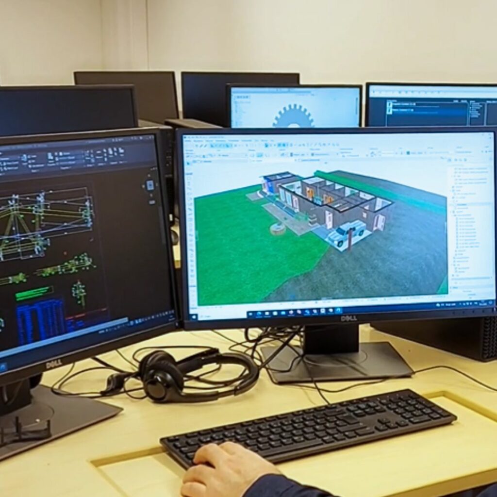 Kuva luokasta, jossa näkyy tietokoneen näyttöjä, joissa auki teknisen suunnittelun perustutkkinnossa käytettäviä ohjelmia.
