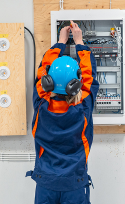 Opiskelija harjoittelee johtojen kytkemistä opiskeluissaan.