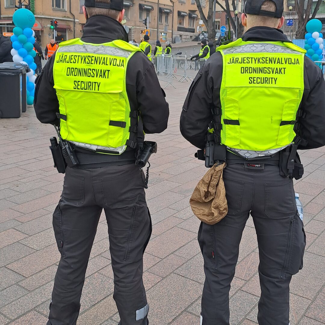 Kaksi järjestyksenvalvojaa seisoo tapahtumassa.